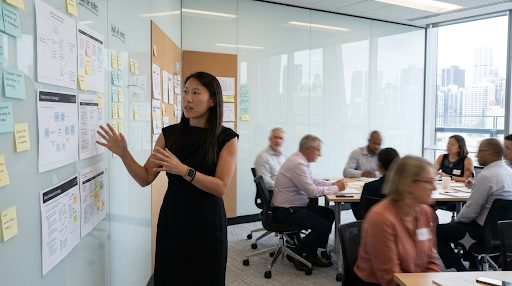 Natasha Fong facilitating a workshop group at a wall of worksheets